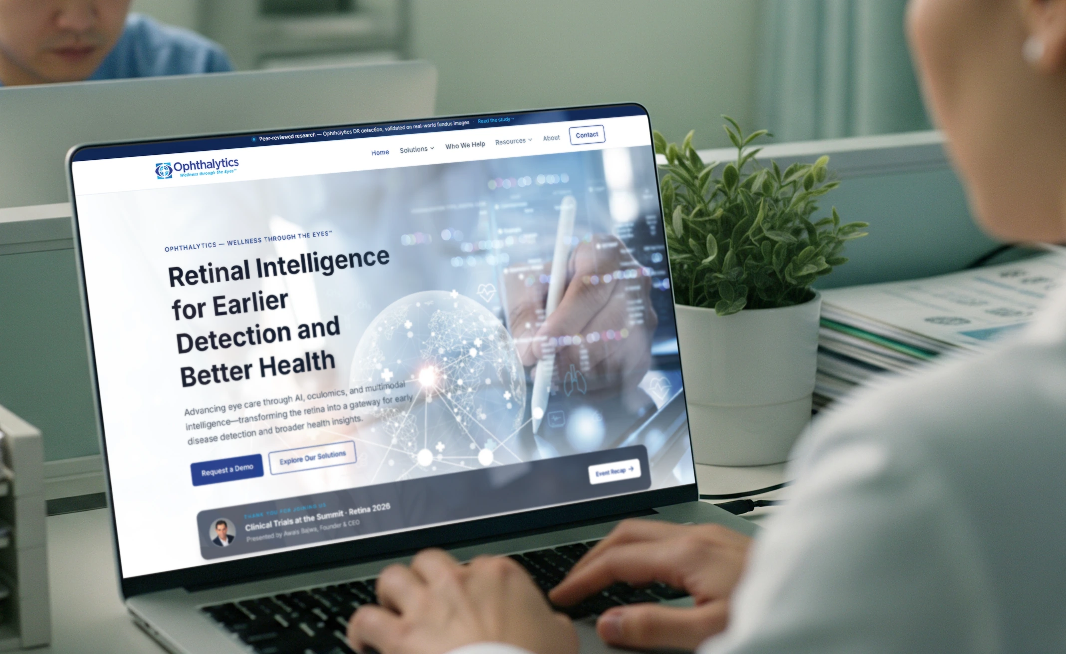 The Ophthalytics homepage composited onto a laptop screen in Photoshop